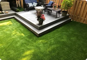 A cozy patio with wooden decking, potted plants