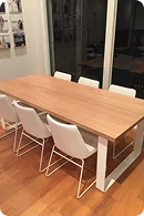 A modern wooden dining table with a white frame