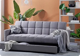 A stylish gray sofa with patterned cushions and a throw blanket