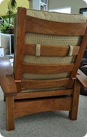 Back view of a sturdy wooden lounge chair with a patterned cushion
