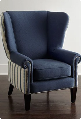 Classic wingback chair with a dark blue fabric and striped side