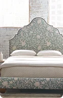Elegant bed with a floral-patterned upholstered headboard