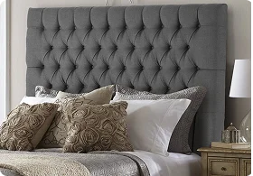 Gray tufted headboard above a neatly made bed