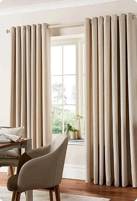 Light beige curtains frame a sunny window