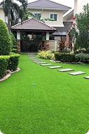 Lush green lawn with stone stepping paths leads to a charming house