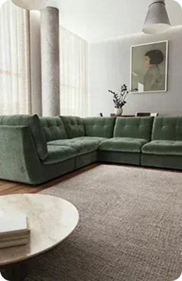 A cozy living area features a plush green sectional sofa
