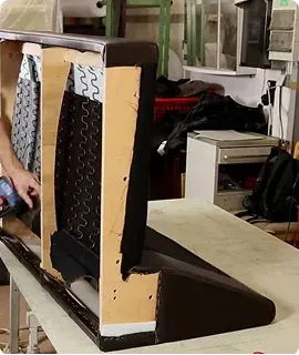 A partially upholstered chair back showcases its frame and springs