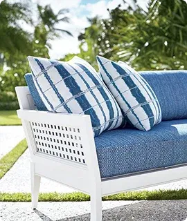 A stylish outdoor sofa with blue cushions and patterned pillows