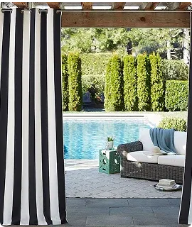 A view of a poolside area with black and white striped curtains