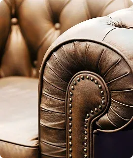 Close-up of a brown leather armchair showcasing tufted upholstery