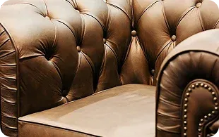 Close-up of a luxurious brown leather armchair with tufted detailing