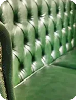 Close-up of a tufted green leather sofa