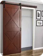 A rustic brown sliding barn door partially opened