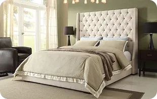 A stylish bed with a tufted beige headboard