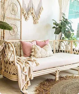 A stylish rattan sofa adorned with pink cushions
