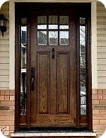 A wooden front door with a rectangular window panel above