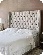 Bed with tufted headboard and white bedding
