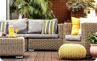 Outdoor seating area with cushions, drinks, and plants