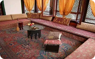 Seating area with patterned cushions and decorative curtains