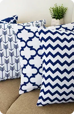 Three decorative pillows with navy blue patterns—arrows