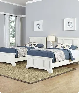 Two twin beds with blue bedding in a room
