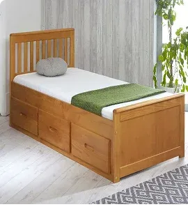 Wooden single bed with storage drawers and green blanket